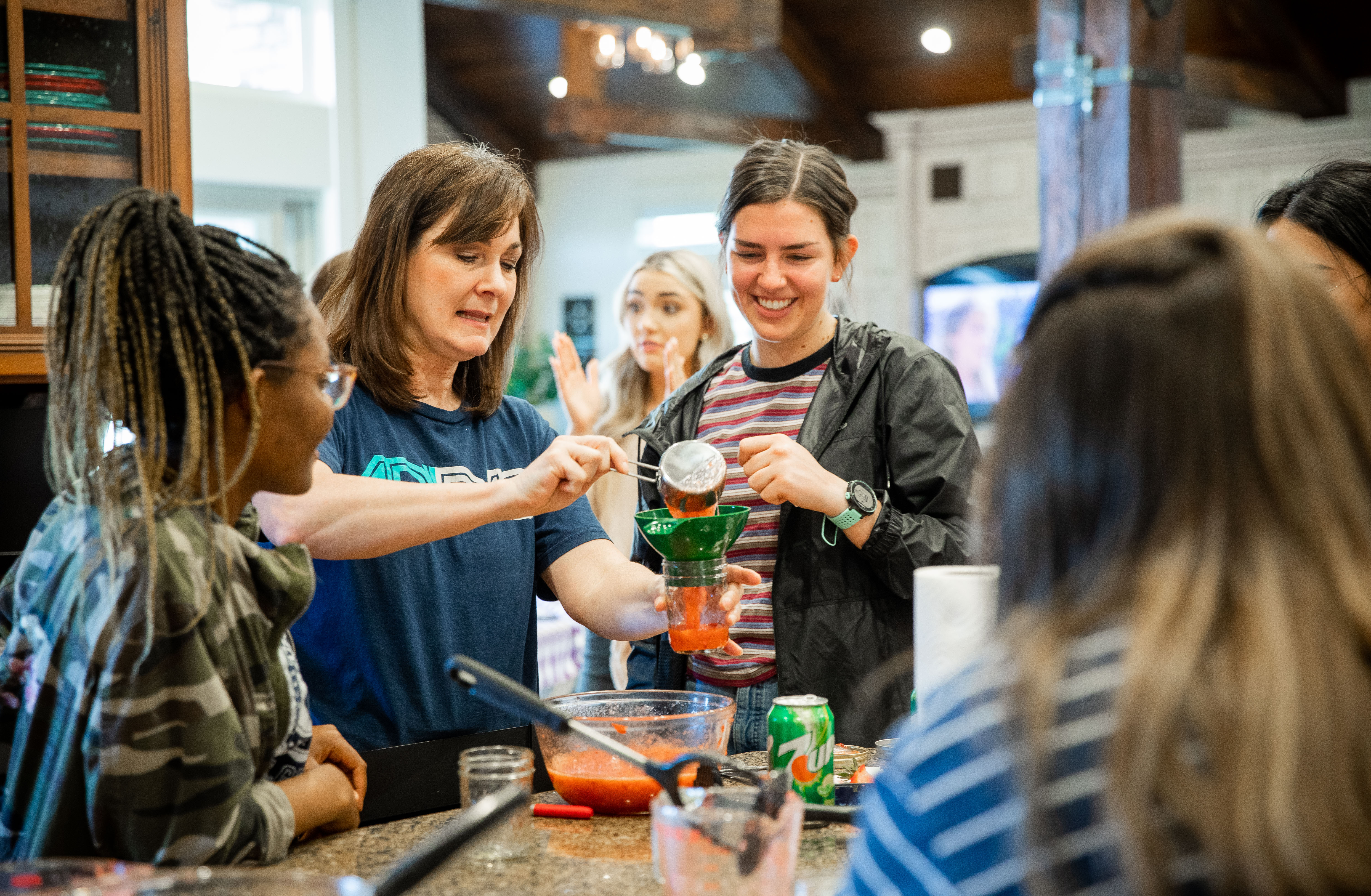 Several female BYU-Idaho students learn how to make and can homemade strawberry jam during a Relief Society activity. 